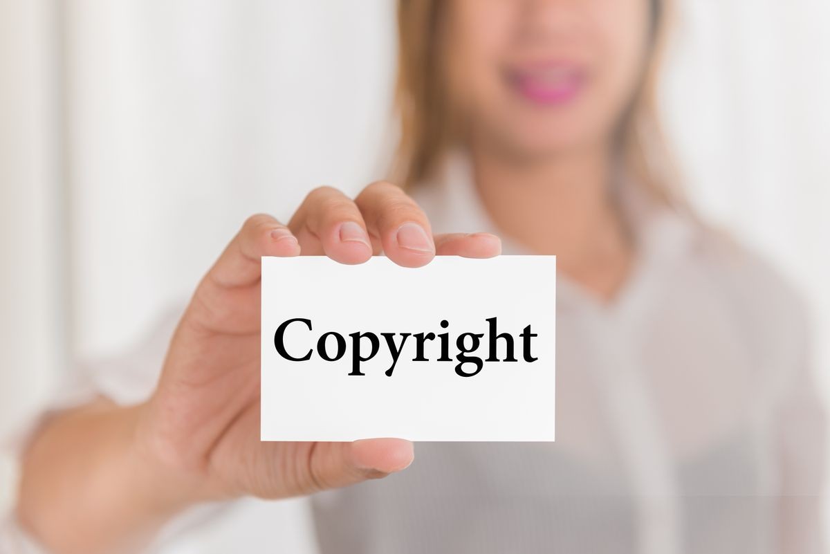 Copyright message word on card in hand of Friendly woman hand and smiling